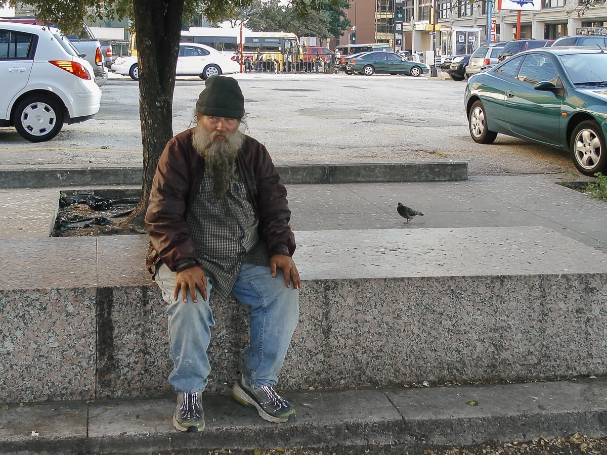Homeless man and pigeon in downtown Dallas