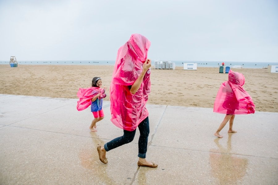 A mom and her daughters running in the rain in Chicago Illinois
