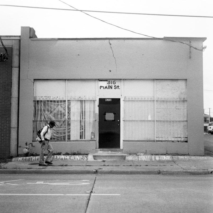 A man walking in front of an old store front