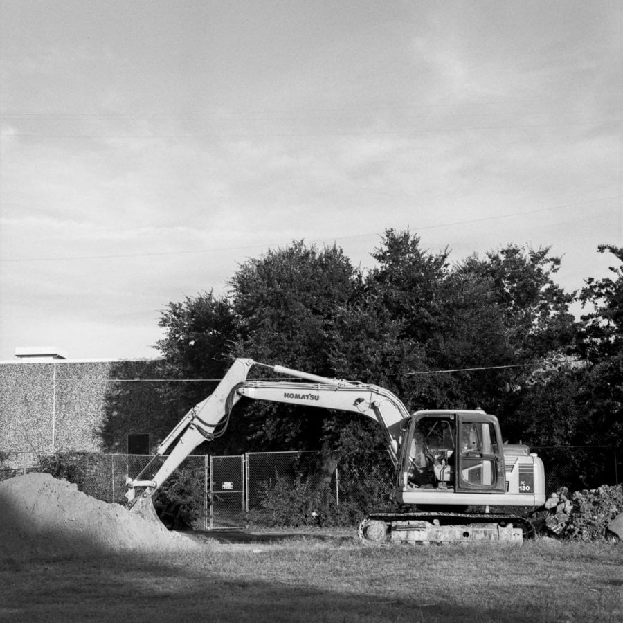 An excavator clearing a plot of land