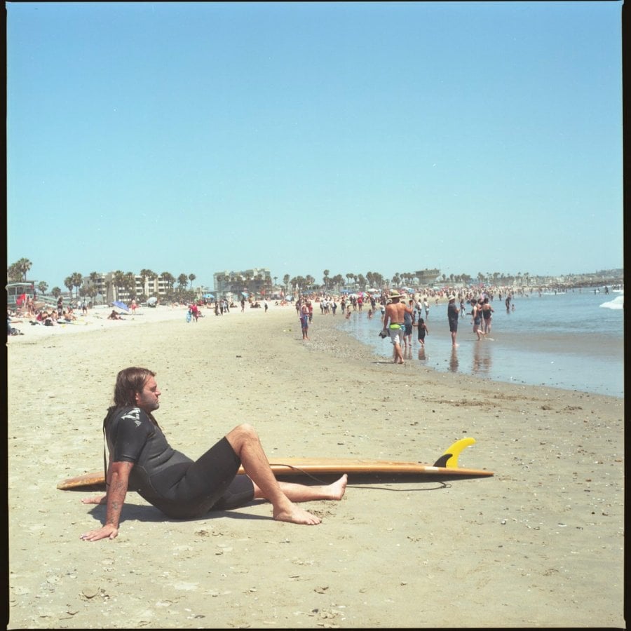 A surfer relaxing on the beach, California 