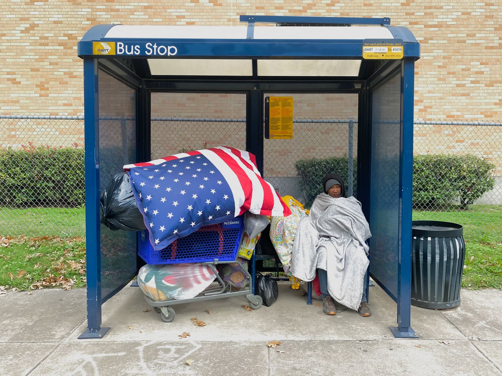 A homeless woman with an American Flag comforter in Dallas, Texas