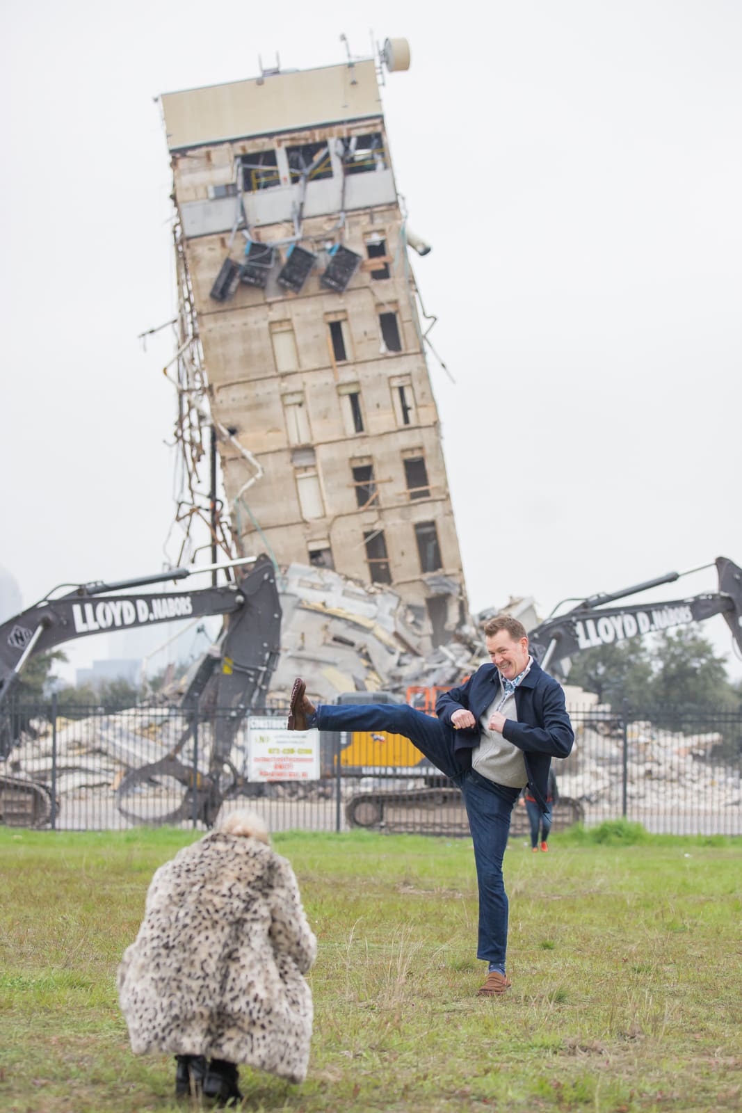 A man posting with the "Leaning Tower of Dallas." 2020 Best Photos.