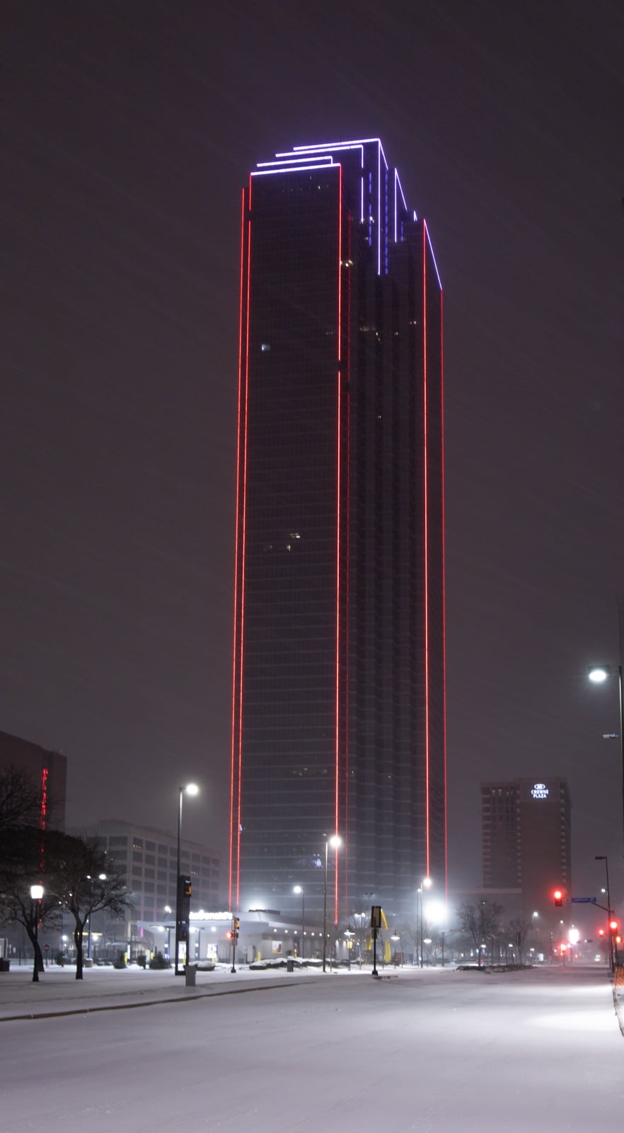 Bank of America Plaza with red lights at night on a snowy evening
