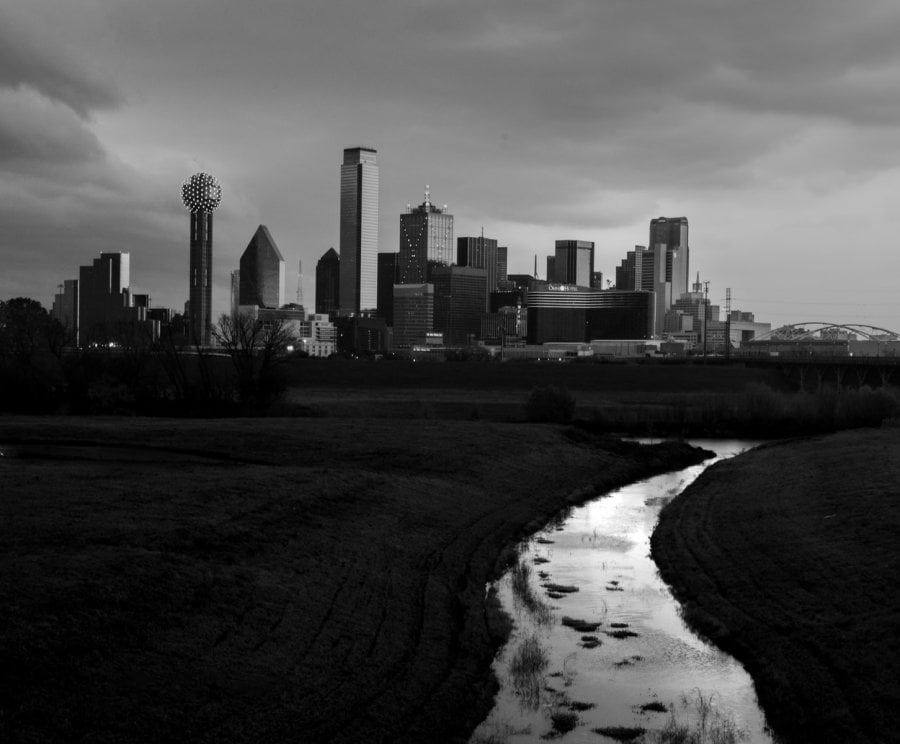 A black and white photo of The Dallas skyline with the trinity river 