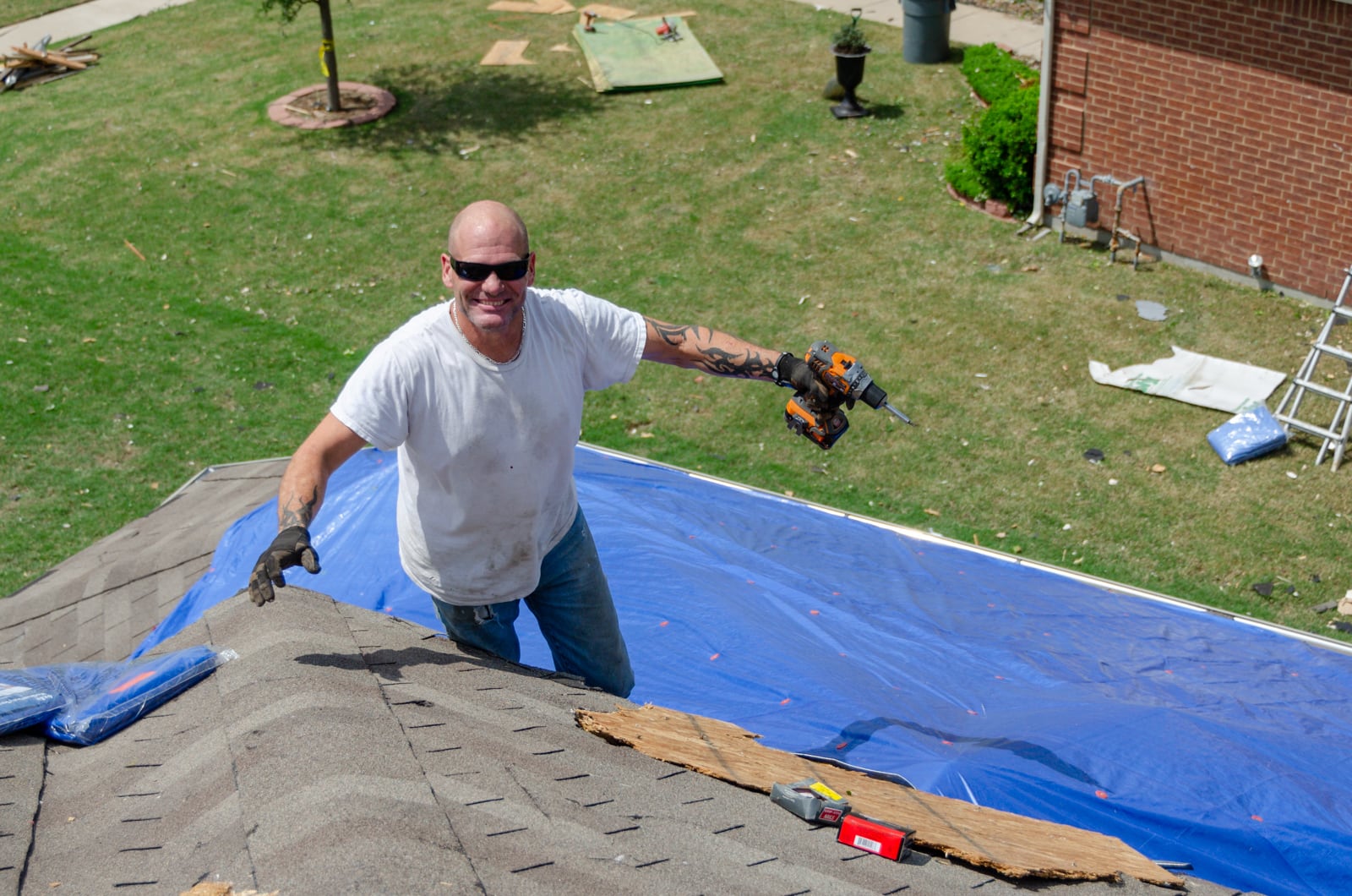 A man helping repair his friend's roof