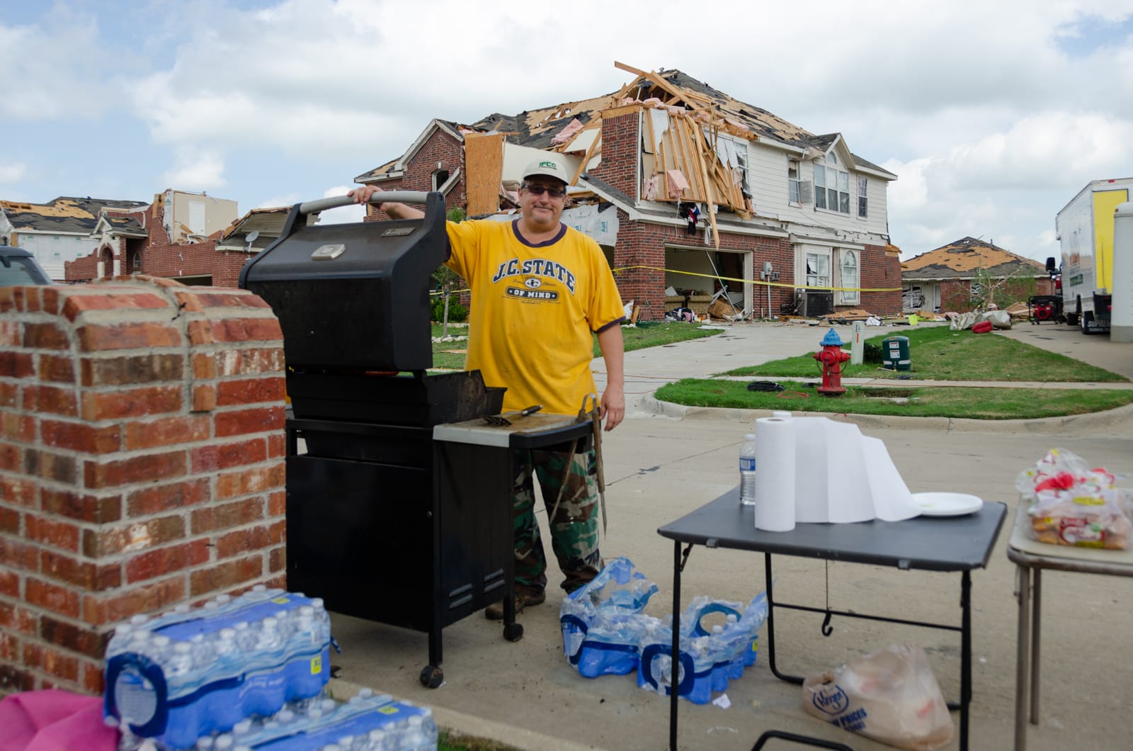Steve grilling food for people who are cleaning up after their homes were hit by a tornado