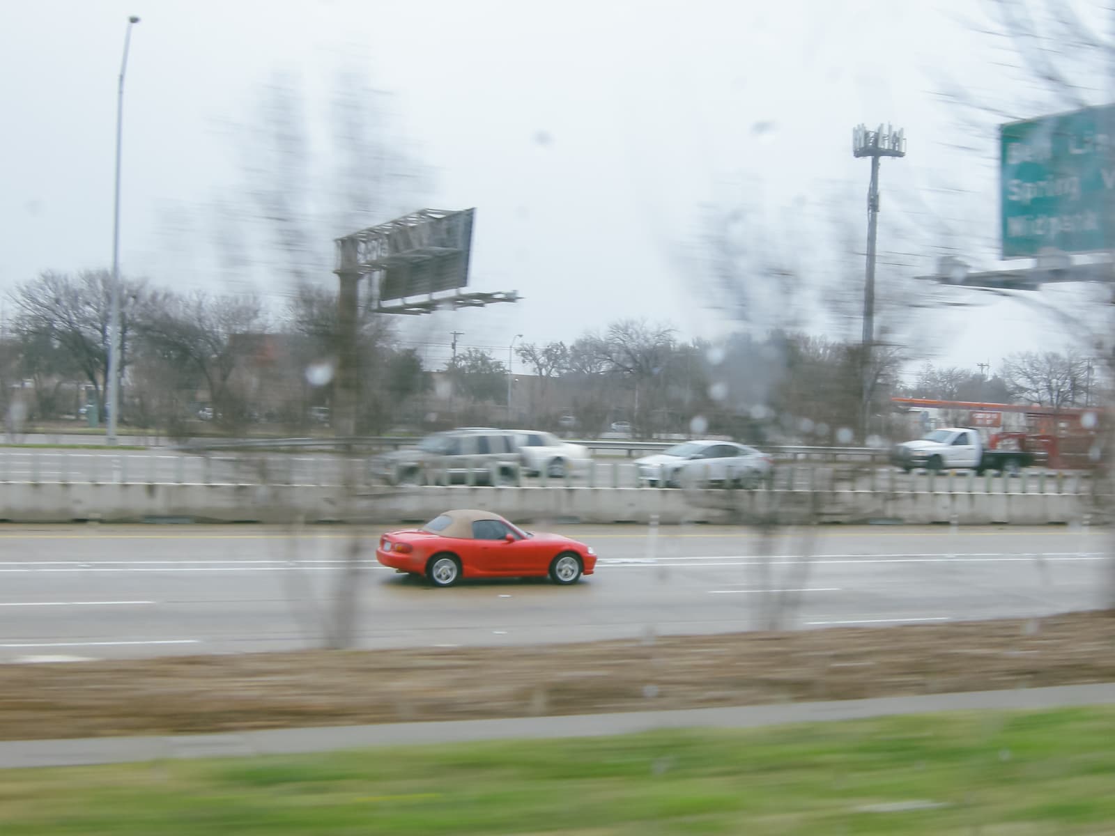 A red car driving on highway 75