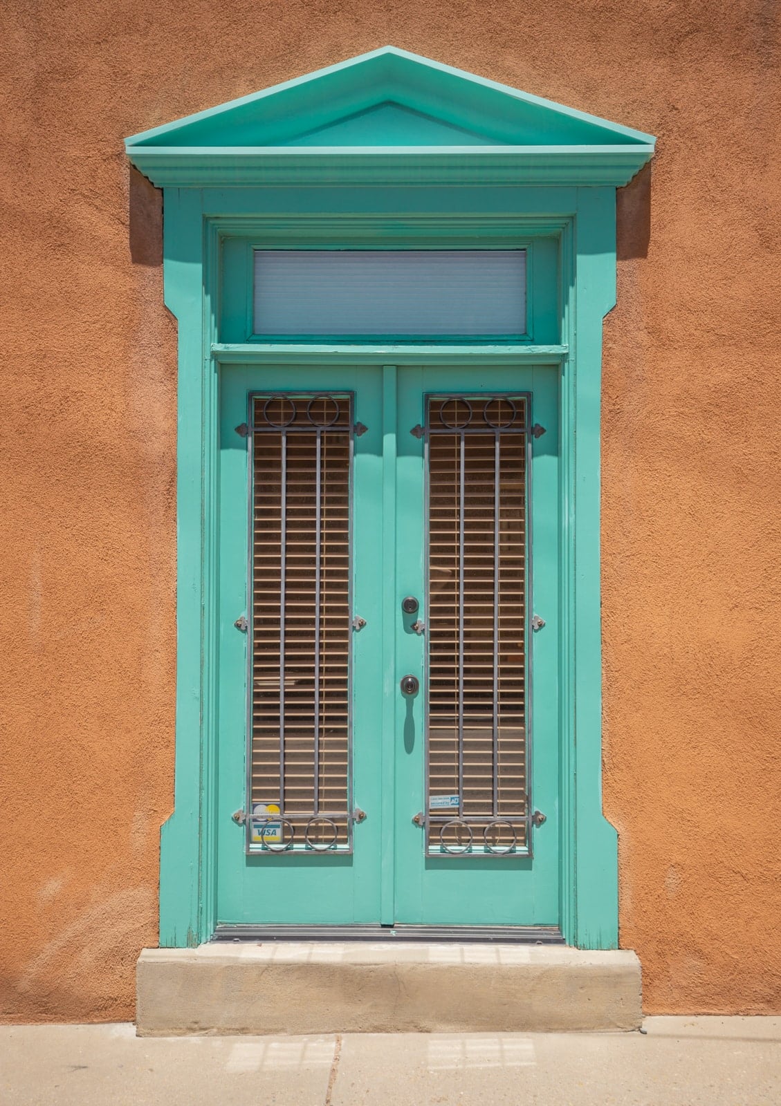 A turquoise window frame in an adobe style building