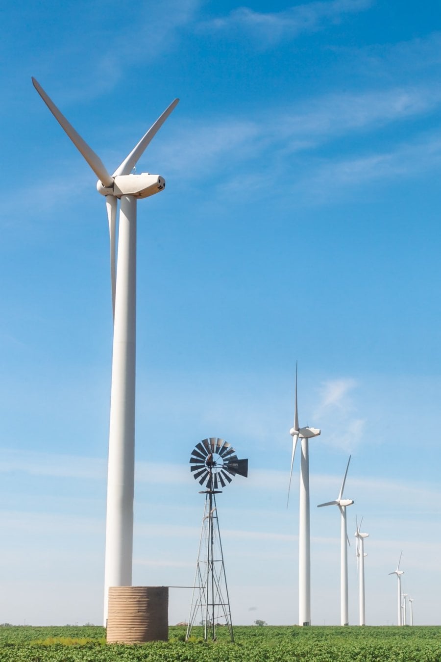 An old wind mill with new wind mills