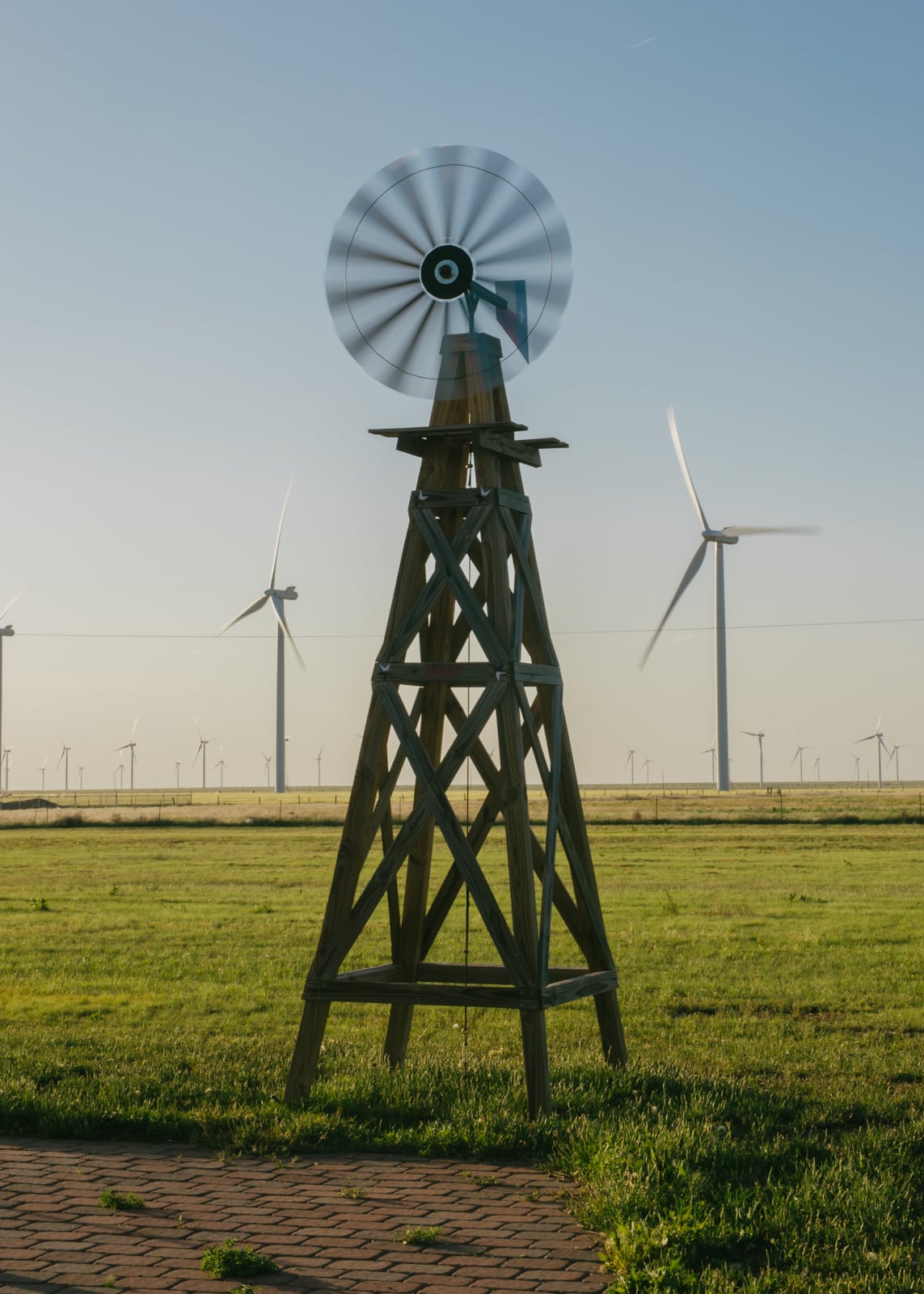 An old windmill by a wind farm 