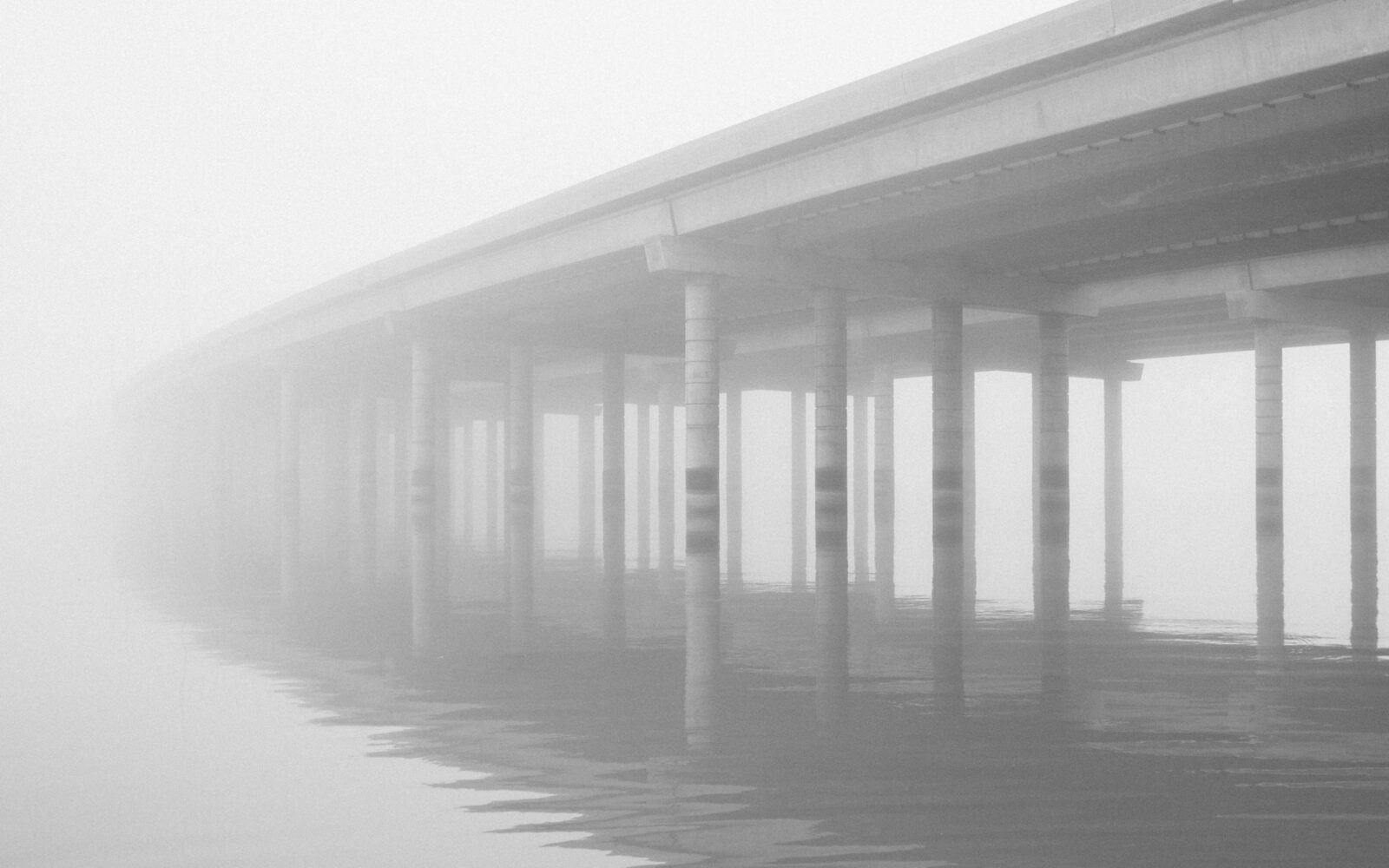 A Bridge In Fog Extending Into The Mysterious White Nothingness