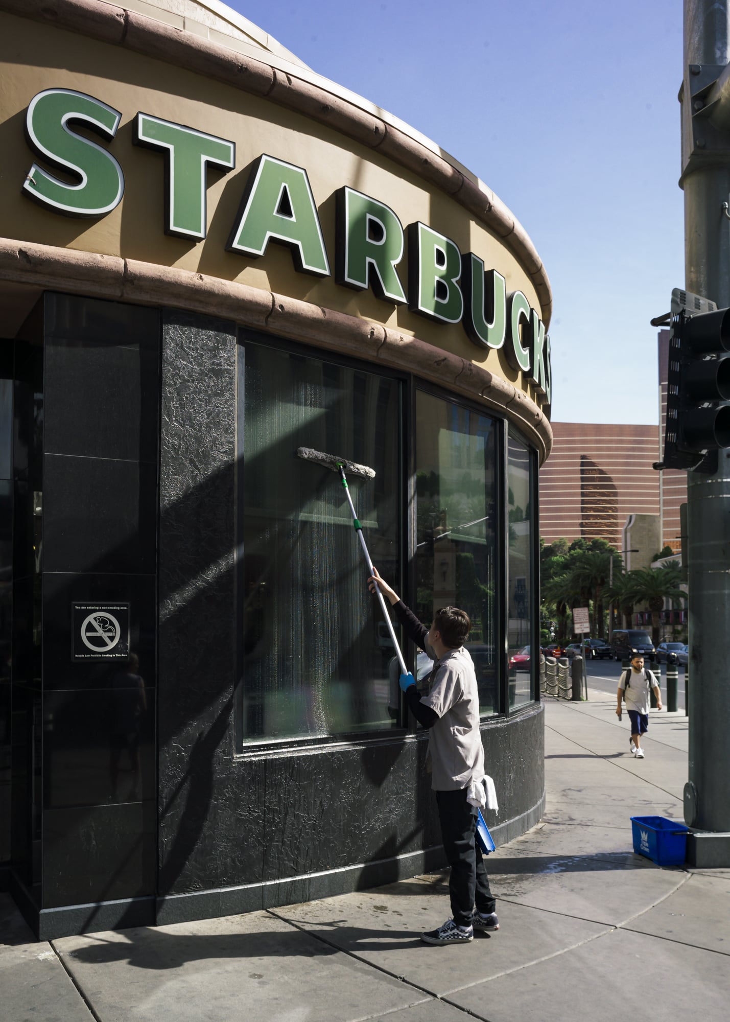 A man cleaning Starbucks windows