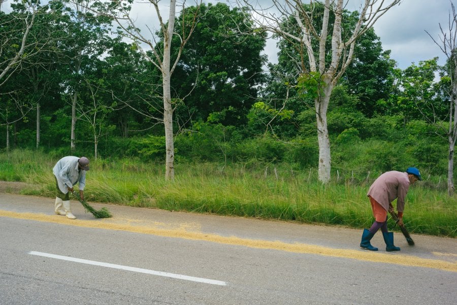two men trying rice in the street in Antonio De Las Vueltas, Cuba