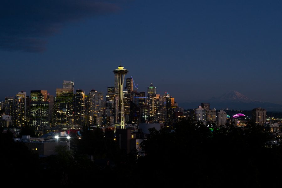 Seattle skyline at night with Mt. Rainier in the distance. 