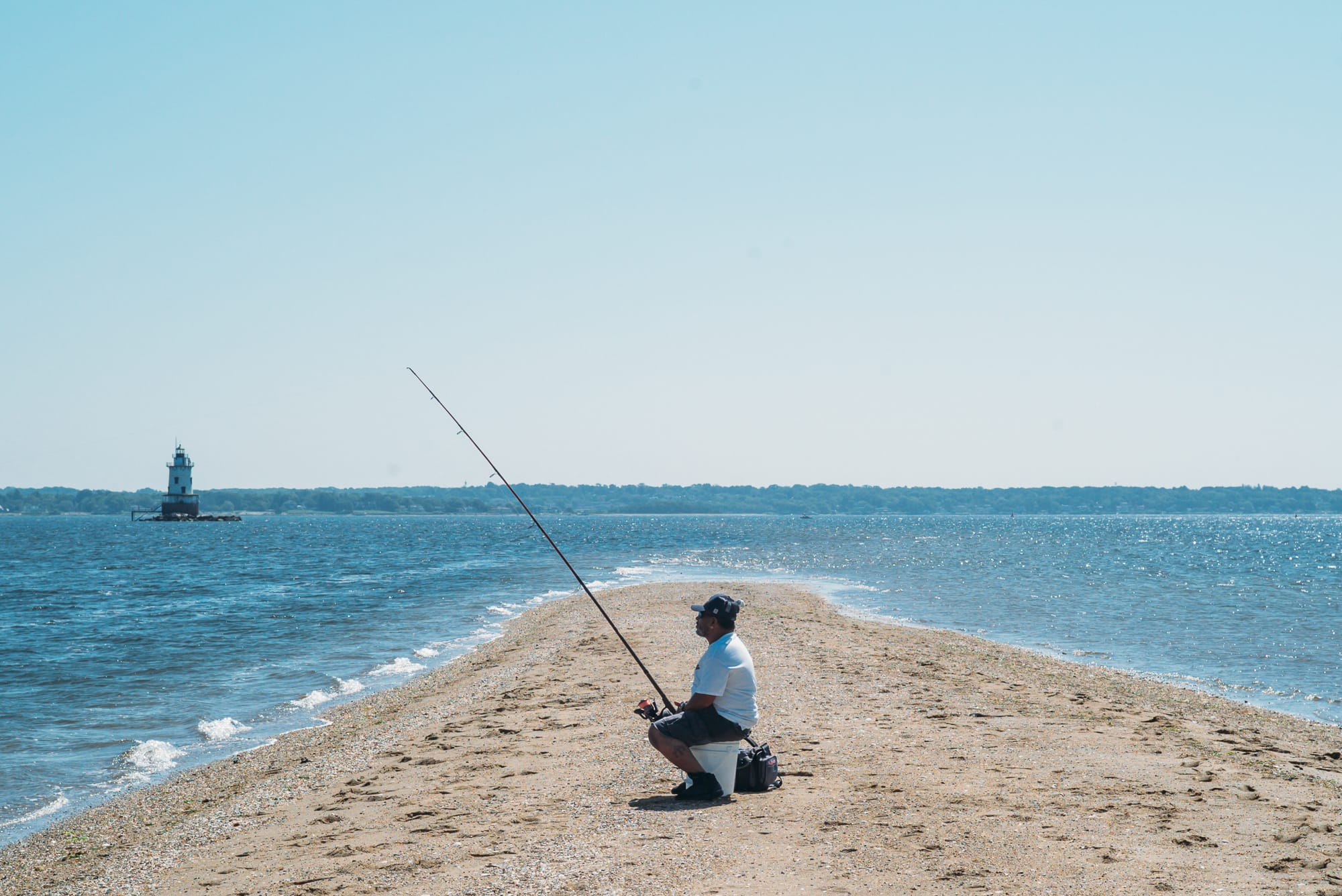 A man fishing on the beach in Conimicut Point, Warwick, Rhode Island
