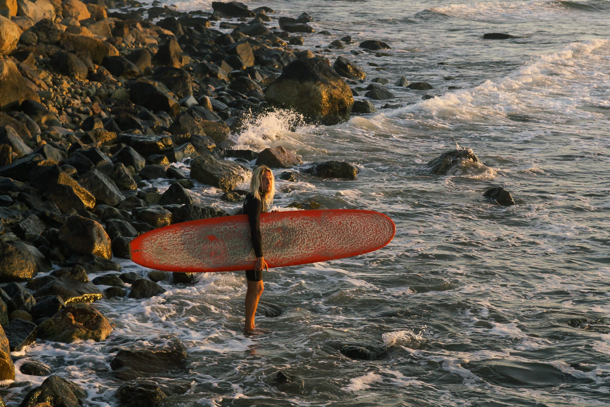 A surfer at Point Judith, Narragansett during sunrise
